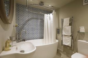 une salle de bain avec une baignoire, un lavabo et une douche dans l'établissement Daisybank Cottage Boutique Bed and Breakfast, à Brockenhurst 50 autres photos