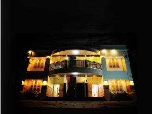 a large white building with a balcony at night at Amara Lux Rivage wynad in Vythiri