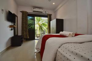 a bedroom with two beds and a large window at Da Down Resort & Hotel in Candolim