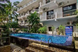 a swimming pool in front of a building at Da Down Resort & Hotel in Candolim