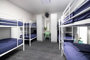a dorm room with bunk beds and a desk at Spinners Hostel in Perth