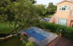a swimming pool in the yard of a house at Dulle House Jeju in Jeju