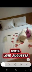 a poster of a hotel love australia on a bed at Hotel Love Augustta in São Paulo
