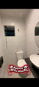 a bathroom with a white toilet and a sink at Hotel Love Augustta in São Paulo