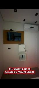 a room with a tv on a wall with a sign at Hotel Love Augustta in São Paulo