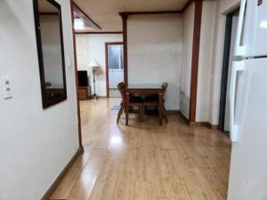 a dining room with a table and a room with a kitchen at Chuncheon Saemmul Dungji Pension in Chuncheon