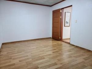 an empty room with a wooden floor and a door at Chuncheon Saemmul Dungji Pension in Chuncheon