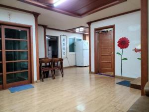 a living room with a table and a door with a flower on the wall at Chuncheon Saemmul Dungji Pension in Chuncheon +2 photos