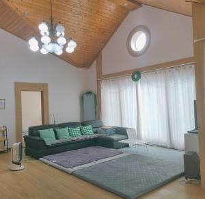 a living room with a green couch and a television at Mooldan Dongsan Taean in Taean
