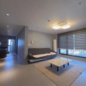 a bedroom with a bed and a coffee table at Gangneung Jitap Pension in Gangneung