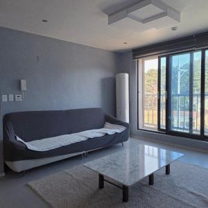a living room with a bed and a coffee table at Gangneung Jitap Pension in Gangneung