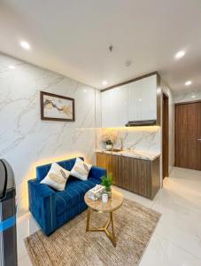 a living room with a blue couch and a table at Rochomes Apartment in Thịnh Châu
