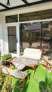 a patio with two chairs and a table on the grass at Pool Lounge Pension & Glamping in Yangyang
