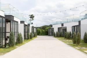 an empty alley between two buildings with trees at Pool Lounge Pension & Glamping in Yangyang