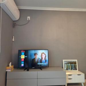 a flat screen tv sitting on top of a dresser at Gangneung Moan Pension in Gangneung