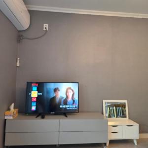 a flat screen tv sitting on top of a dresser at Gangneung Moan Pension in Gangneung