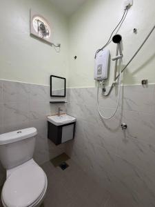 a bathroom with a shower and a toilet and a sink at Dikmad Studio Room Bukit Mentok, Kemaman in Cukai +21 photos