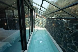a swimming pool in a house with a rock wall at Chaeonjae Gongju in Gongju