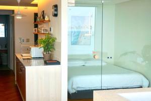 two pictures of a bedroom with a bed and a desk at Busan Neouigyejeol in Busan