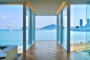 a view of the ocean from a building with glass windows at Busan Neouigyejeol in Busan