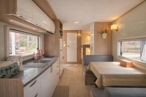 an rv kitchen with a sink and a table at Yeosu Si-in Place Pension in Yeosu