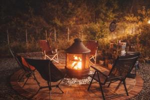 a fire pit with chairs and a table with a fireplace at Yeosu Si-in Place Pension in Yeosu