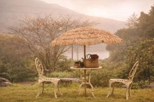 a table and two chairs under an umbrella at Yeosu Si-in Place Pension in Yeosu