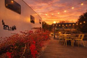 a patio with a table and chairs and a sunset at Yeosu Si-in Place Pension in Yeosu +5 photos