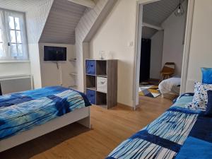 a bedroom with two beds and a tv in it at Les Terrasses de Laguiole in Laguiole