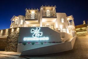 un edificio con una señal delante de él en Anemomiloi Andros Boutique Hotel en Andros