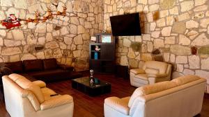 a living room with couches and a stone wall at Villa 2 Senderó del Bosque in Omitlán de Juárez