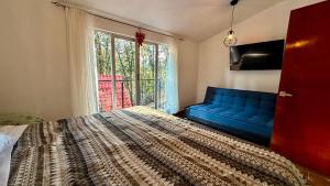 a bedroom with a bed and a couch and a window at Villa 2 Senderó del Bosque in Omitlán de Juárez