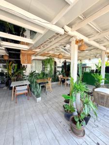 a patio with tables and chairs and potted plants at Hostel Cafe13 in Ko Phangan