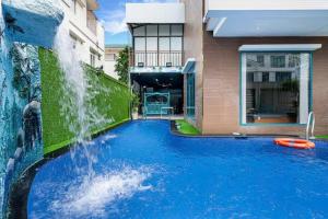 a swimming pool with a waterfall in front of a house at Villa B2-10 Long Cung in Vung Tau