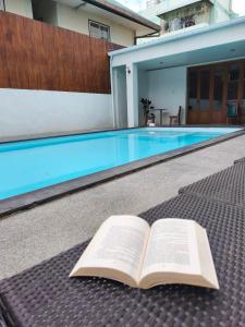 an open book laying on the ground next to a swimming pool at The Wing Lanna Hotel in Chiang Mai