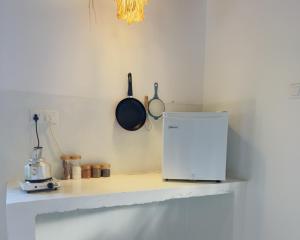 a kitchen counter with a refrigerator and pans on the wall at Ceylon Marley Villa in Talawa