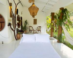 a bedroom with a white bed in a room with trees at Ceylon Marley Villa in Talawa +40 photos