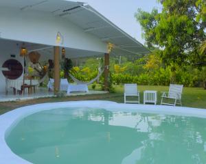 a swimming pool in a backyard with chairs and a tent at Ceylon Marley Villa in Talawa