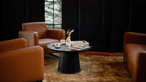 a coffee table in a room with two chairs and a window at The Rest Port Nd Downtown in Edirne