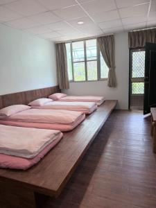 a row of beds in a room with windows at Tanapavana閒雲居 in Alishan