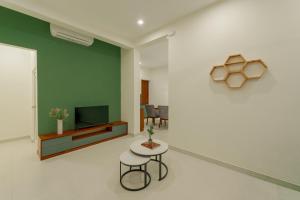 a living room with a table and a television at Mulberry Living in Negombo