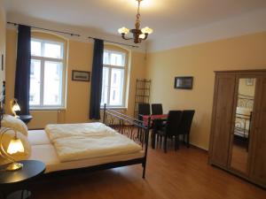 - une chambre avec un lit et une table avec des chaises dans l'établissement Haus Gründerzeit, à Görlitz