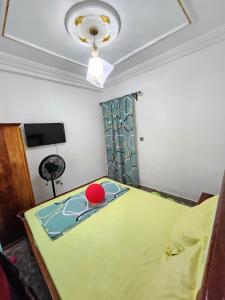 a room with a bed with a red ball on it at FOKOU House in Yaoundé