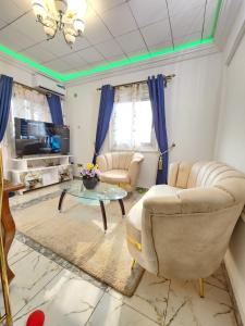 a living room with couches and a tv and a table at FOKOU House in Yaoundé