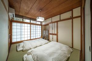 a bedroom with two beds in a room with windows at Yuen in Beppu +24 photos