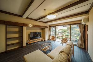 a living room with a couch and a tv at Yuen in Beppu