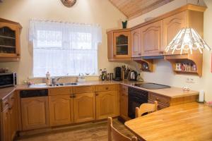 una cucina con armadi in legno, lavandino e finestra di Hvammur Apartments a Höfn