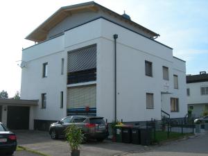 a white building with a car parked in front of it at Paul's Home in Klagenfurt