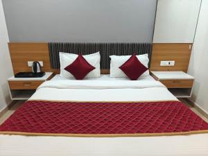 a bed with red pillows in a room at Hotel Vivank in Kolhapur +36 photos
