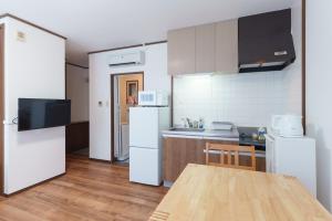 a kitchen with white appliances and a wooden table at Kent Clair Ishigaki Bay in Ishigaki Island